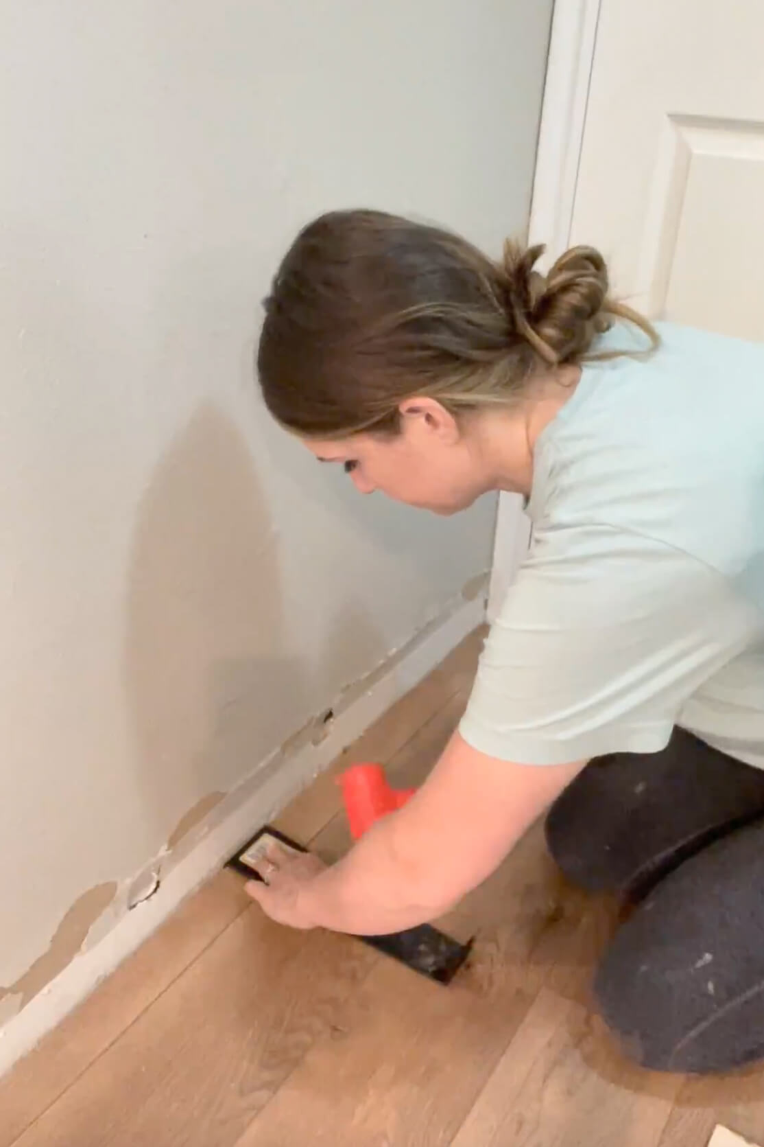 Using a pull bar to install laminate flooring.